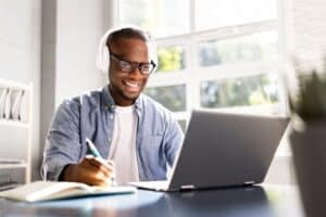 Man in headphones studies at ABPN® exam at laptop.